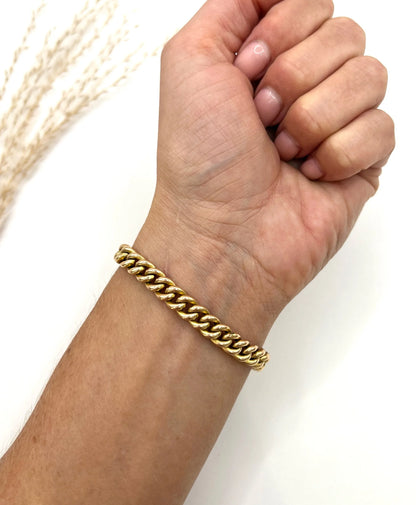 A gold curb link bracelet, modelled on a wrist