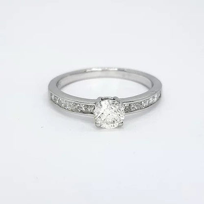 Diamond Solitaire Engagement Ring with Princess Cut Shoulders; central 0.52 carat round brilliant-cut diamond, four-claw set, flanked by 0.43cts channel-set princess-cut diamond set shoulders, in 18ct white gold