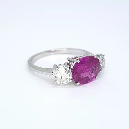 Pink Sapphire and Diamond Three Stone Ring; 2.30ct oval cut pink sapphire flanked by 0.97cts brilliant cut diamonds, in 18ct white gold