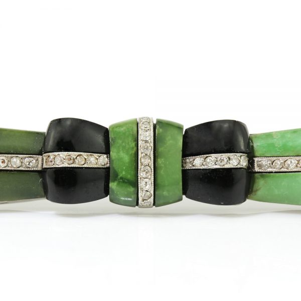 Art Deco Jadeite, Onyx and Old Cut Diamond Bow Brooch in Platinum; set with jadeite accented with onyx and 0.50cts old-cut diamonds, Circa 1920s