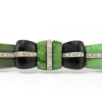 Art Deco Jadeite, Onyx and Old Cut Diamond Bow Brooch in Platinum; set with jadeite accented with onyx and 0.50cts old-cut diamonds, Circa 1920s