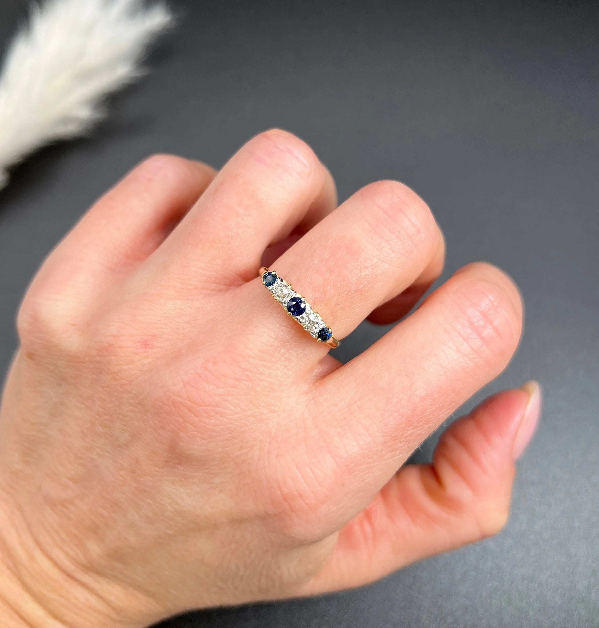 A yellow gold five stone sapphire and diamond carved half hoop ring, modelled on a hand
