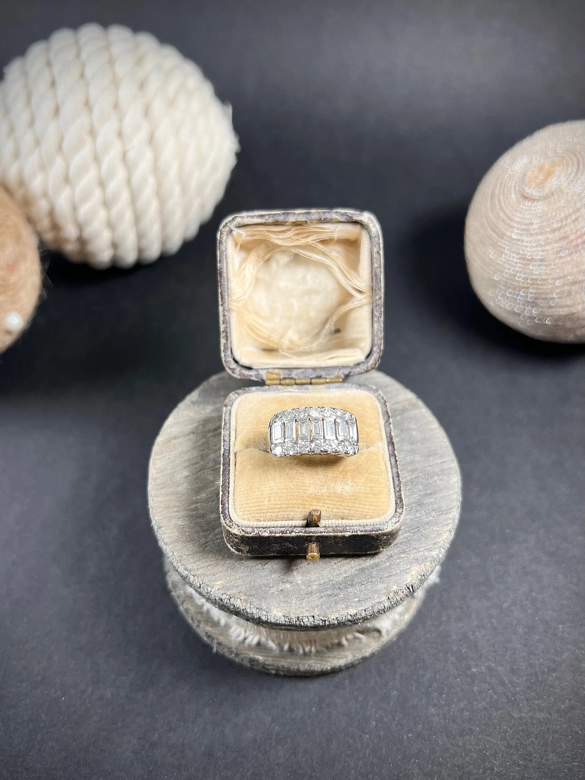 A three row diamond band ring in platinum in an antique ring box
