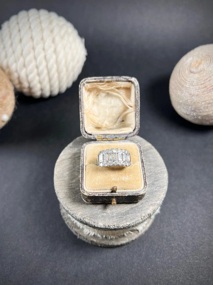 A three row diamond band ring in platinum in an antique ring box
