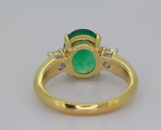 Oval Emerald and Diamond Trilogy Ring, in 18ct yellow gold.