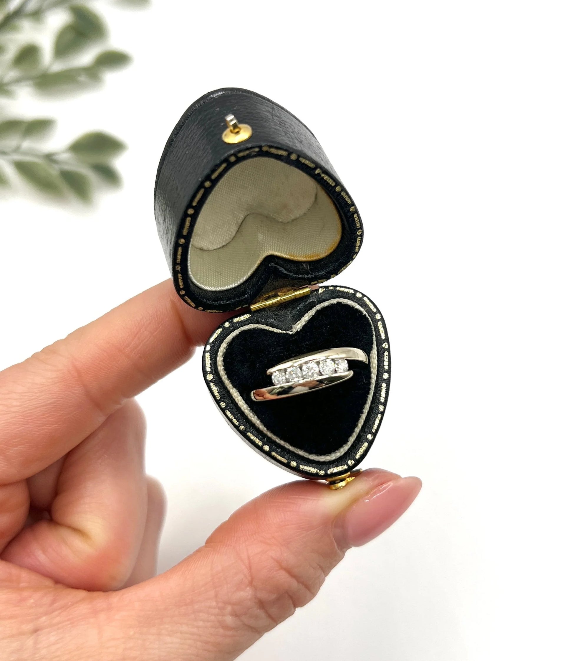 A five stone brilliant cut diamond ring in white gold, in a heart-shaped ring box