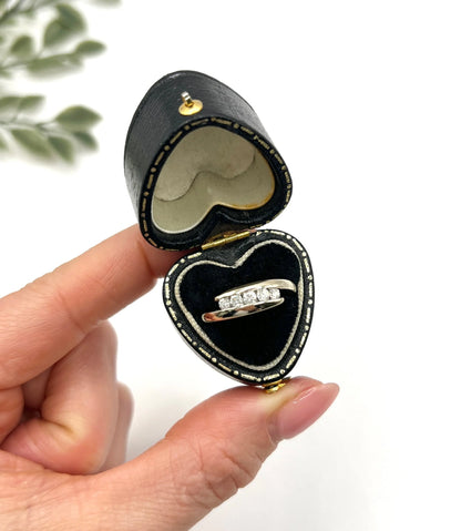 A five stone brilliant cut diamond ring in white gold, in a heart-shaped ring box