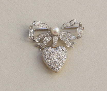 Antique Edwardian Diamond and Pearl Bow and Heart Locket Brooch; set with 1.08cts old-cut diamonds and a natural pearl, platinum and 18ct gold