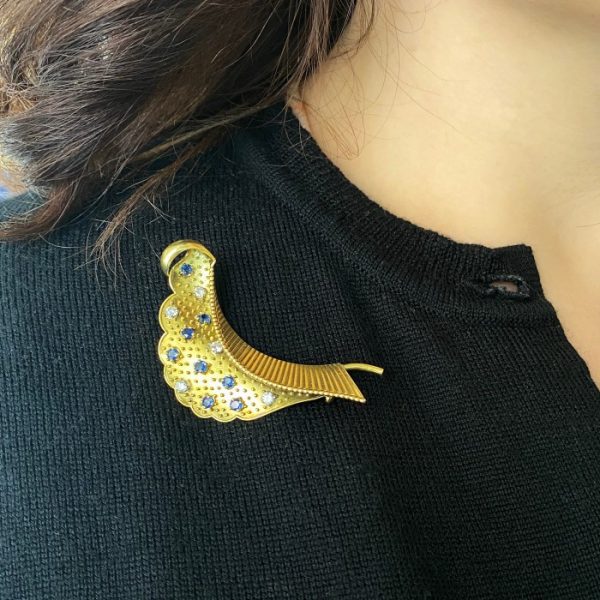 Cartier Vintage Sapphire Diamond and Gold Brooch; stylised folded leaf decorated with gold studs, brilliant diamonds and sapphires, Circa 1960