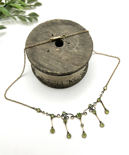 A yellow gold swag necklace with peridot drops