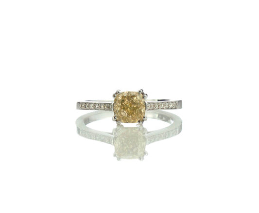 Fancy Yellow Diamond Engagement Ring, 1.24 carat cushion-cut fancy yellow diamond, double four-claw set and accented with diamond set shoulders. Circa 1990s. Fully hallmarked. Comes with AIG certificate.