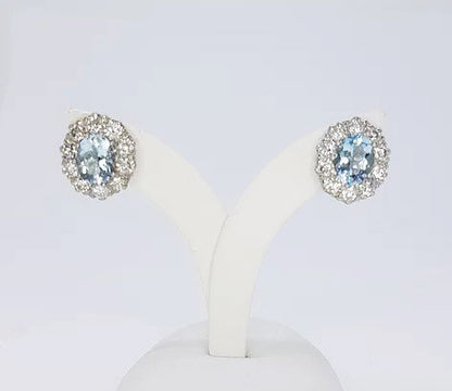Aquamarine and Diamond Oval Cluster Earrings; 2.50cts oval aquamarines surrounded by 1.90cts round brilliant-cut diamonds, in 18ct white gold