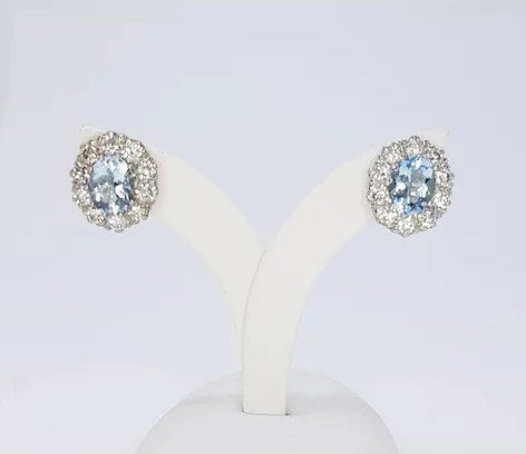 Aquamarine and Diamond Oval Cluster Earrings; 2.50cts oval aquamarines surrounded by 1.90cts round brilliant-cut diamonds, in 18ct white gold