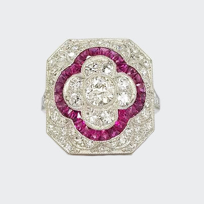Ruby, Diamond and Platinum Panel Cluster Cocktail Ring; A diamond set panel ring, with central motif of calibre-cut rubies. Crafted from platinum.