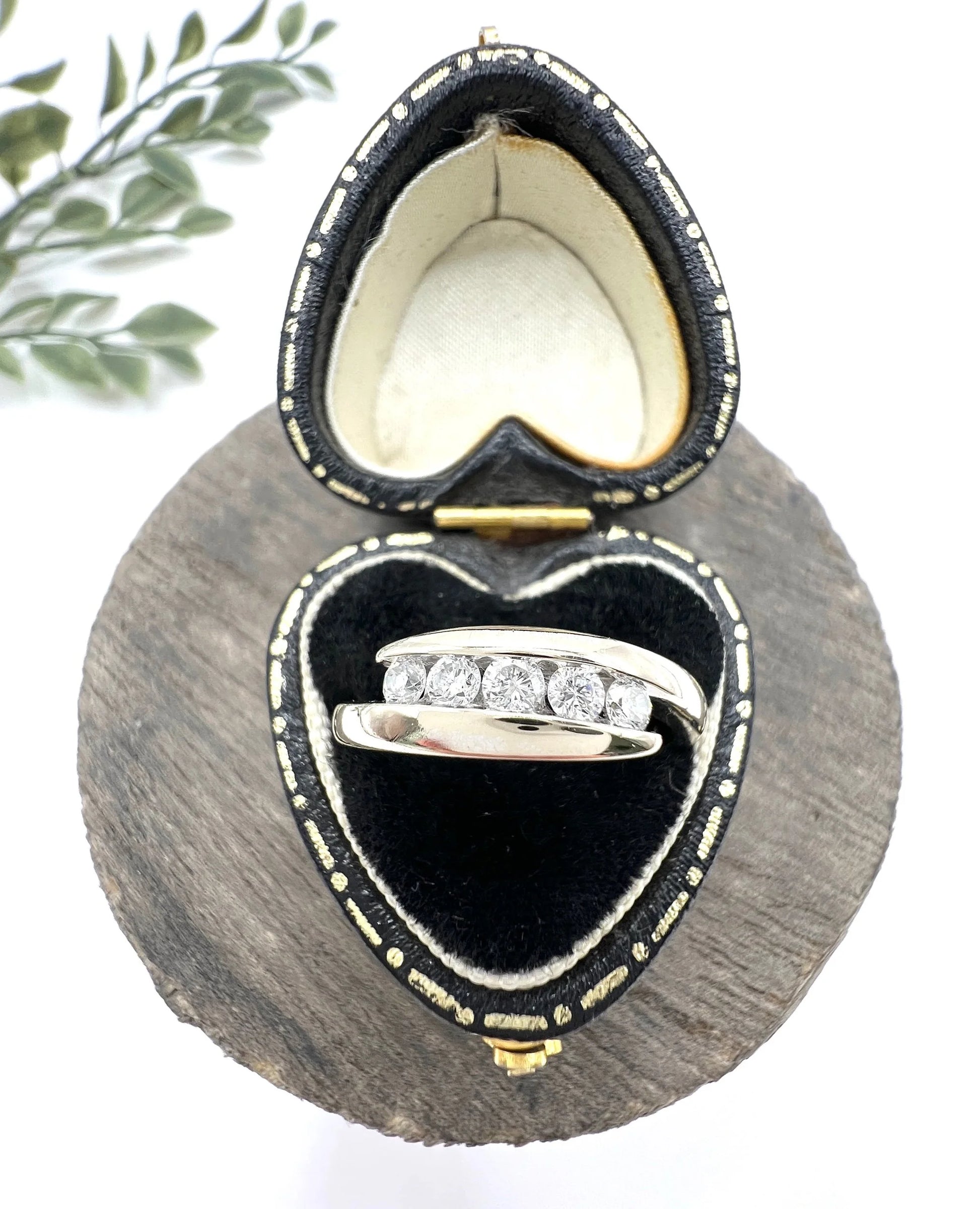 A five stone brilliant cut diamond ring in white gold, in a heart-shaped ring box
