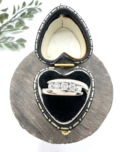 A five stone brilliant cut diamond ring in white gold, in a heart-shaped ring box