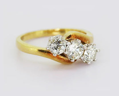 Vintage 1.30ct Diamond Three Stone Crossover Ring; claw set in 18ct white gold, on 18ct yellow gold shank. Total diamond weight estimated to be 1.30 carats.