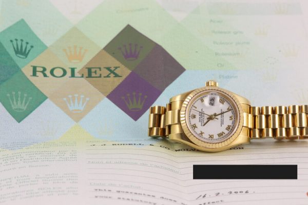 Rolex Lady Datejust 18ct Yellow Gold 179178 Automatic Watch; white dial, Roman numerals, date indicator and sapphire crystal, 18ct yellow gold President bracelet with 18ct yellow gold Crownclasp, with Rolex box and papers.
