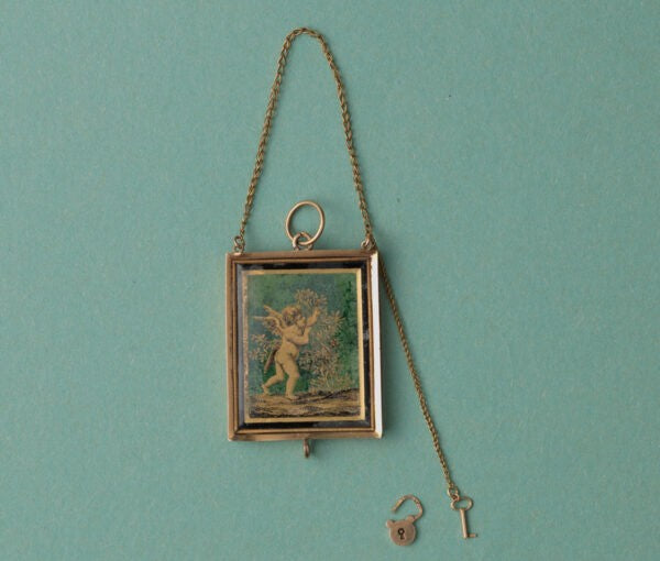 Early 19th Century 18ct Gold Angel Locket; black and gold gilded angel picking roses, miniature key and lock, French gold mark for 1809-1819