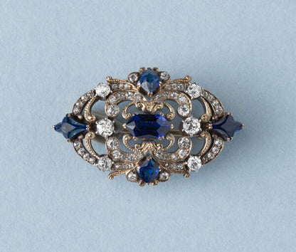 Antique Victorian 3.77ct Sapphire and Diamond Brooch; mixed cut sapphires accented with 1.52cts old-cut diamond set swirls. 19th century.