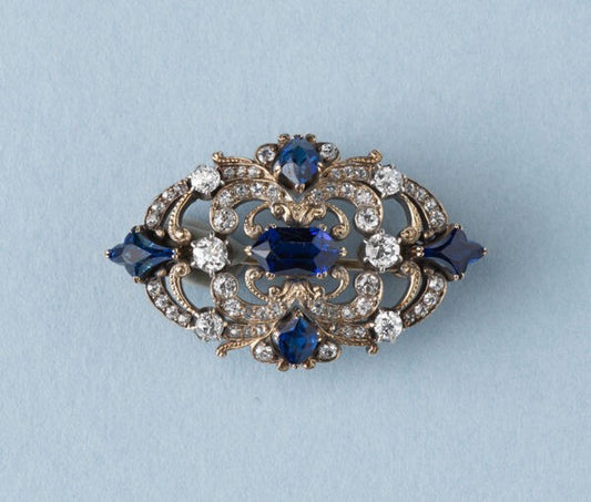 Antique Victorian 3.77ct Sapphire and Diamond Brooch; mixed cut sapphires accented with 1.52cts old-cut diamond set swirls. 19th century.
