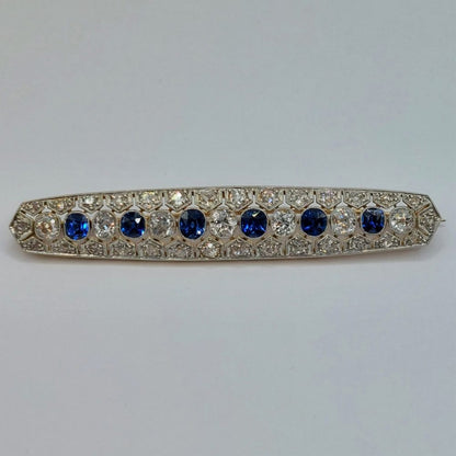Antique Sapphire and Old Cut Diamond Bar Brooch; featuring a line of alternated oval blue sapphires and old mine-cut diamonds, all surrounded by rose cut diamonds in an openwork platinum mount with millegrain edging and backed with 15ct yellow gold. Sapphires 1.00 carat, Diamonds 1.75 carats