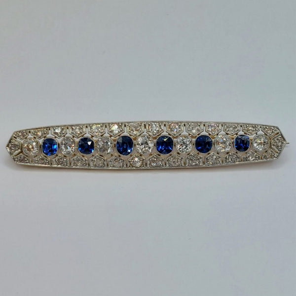 Antique Sapphire and Old Cut Diamond Bar Brooch; featuring a line of alternated oval blue sapphires and old mine-cut diamonds, all surrounded by rose cut diamonds in an openwork platinum mount with millegrain edging and backed with 15ct yellow gold. Sapphires 1.00 carat, Diamonds 1.75 carats