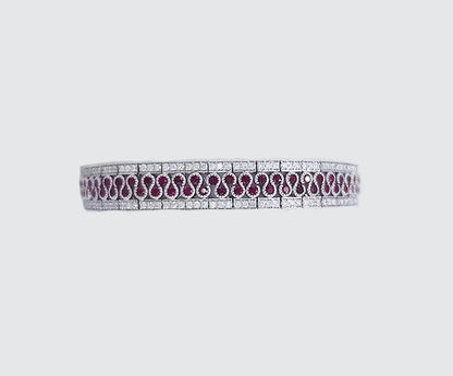 5.80ct Ruby and Diamond Bracelet; central diamond set swirl highlighted by rubies and flanked either side by diamonds, rubies 5.80cts, diamond 2.56cts, in 18ct white gold