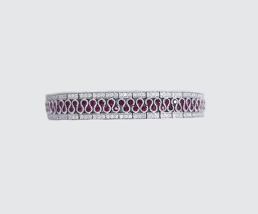 5.80ct Ruby and Diamond Bracelet; central diamond set swirl highlighted by rubies and flanked either side by diamonds, rubies 5.80cts, diamond 2.56cts, in 18ct white gold