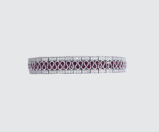 5.80ct Ruby and Diamond Bracelet; central diamond set swirl highlighted by rubies and flanked either side by diamonds, rubies 5.80cts, diamond 2.56cts, in 18ct white gold