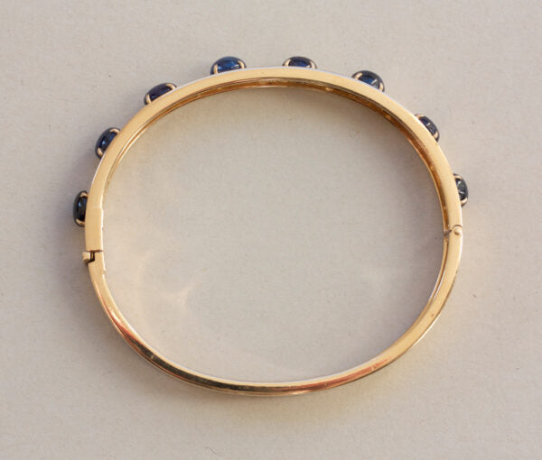 Vintage Sapphire, Diamond and 18ct Yellow Gold Bangle Bracelet; set with 7.00cts oval cabochon sapphires and 0.42cts brilliant cut diamonds