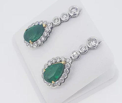 Fine pair of Emerald and Diamond Pear Shaped Cluster Drop Earrings; 6.13cts emeralds, surrounded by 2.67cts sparkling diamonds, in 18ct gold