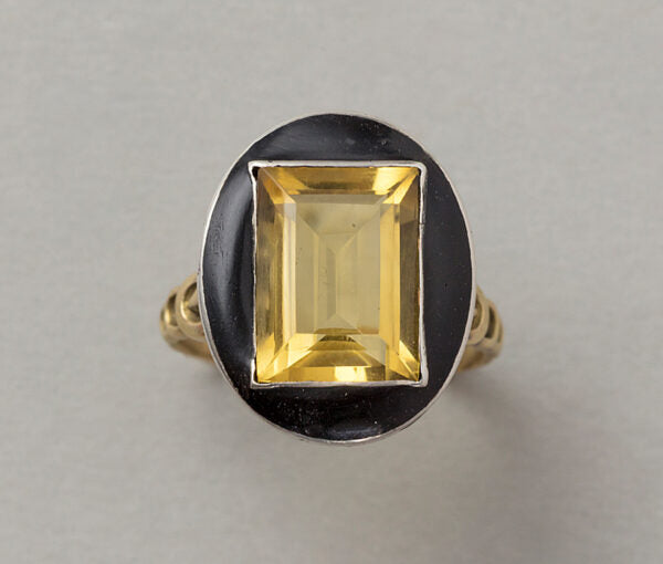 Art Deco French Citrine and Black Enamel Ring; featuring a large step cut citrine that pops from a black enamel frame, set in silver to 18ct yellow gold gallery and shank, Circa 1920