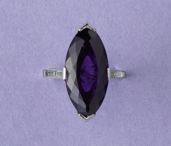 Art Deco Marquise Cut Amethyst, Diamond and Platinum Cocktail Ring; featuring a deep purple navette cut amethyst with brilliant-cut diamond set arches and baguette-cut diamond set shoulders