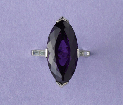 Art Deco Marquise Cut Amethyst, Diamond and Platinum Cocktail Ring; featuring a deep purple navette cut amethyst with brilliant-cut diamond set arches and baguette-cut diamond set shoulders