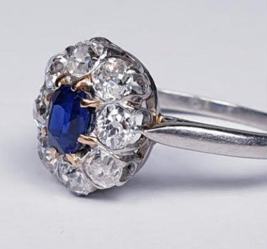 Art Deco Sapphire and Diamond Cluster Engagement Ring; 0.60ct royal blue oval cut sapphire surrounded by 0.80cts old cut diamonds