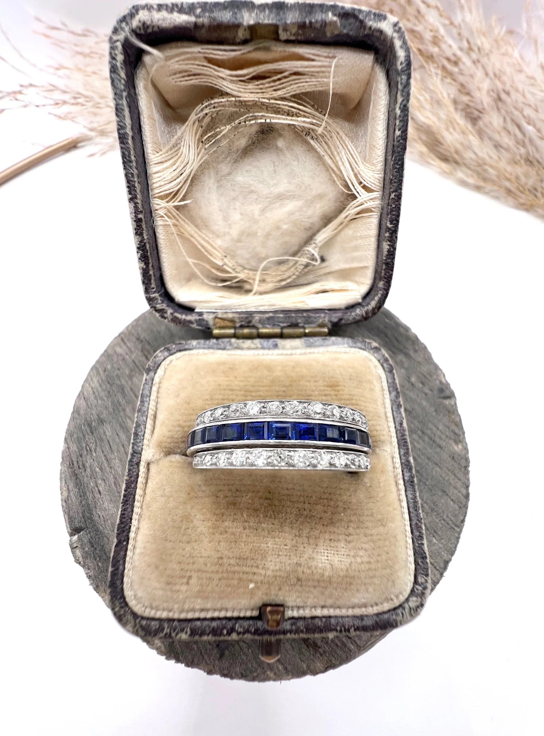 A platinum night and day flip band ring set with diamonds, sapphires and rubies, in a ring box
