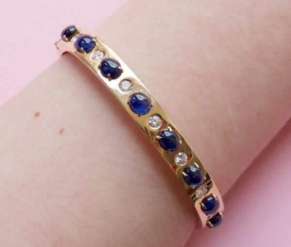 Vintage Sapphire, Diamond and 18ct Yellow Gold Bangle Bracelet; set with 7.00cts oval cabochon sapphires and 0.42cts brilliant cut diamonds. Italy, Circa 1980