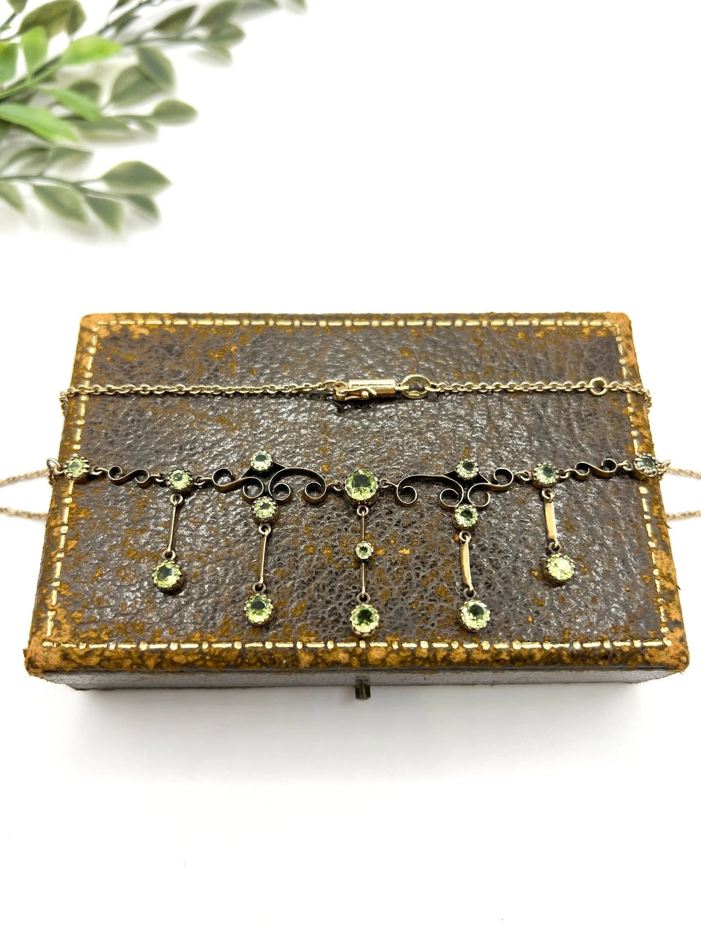 A yellow gold swag necklace with peridot drops