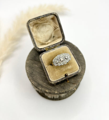 A diamond triple cluster ring in yellow and white gold, in a ring box