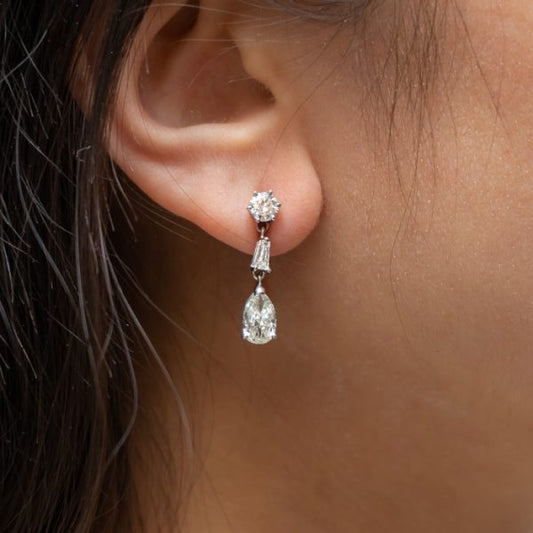 Pear Cut Diamond Drop Earrings in Platinum; round brilliant-cut diamond studs suspend pear shaped diamonds via tapered baguette diamonds, 2.75 carat total