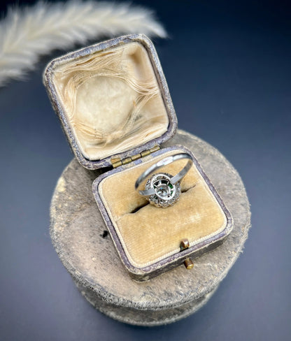 An emerald and diamond target cluster ring in platinum