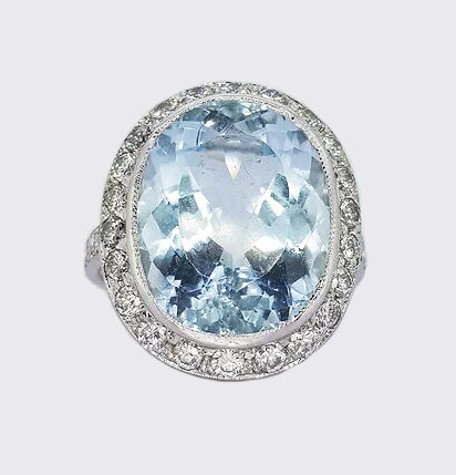 22ct Aquamarine and Diamond Oval Cluster Ring; 22.00 carat oval faceted aquamarine surrounded by 2.50cts diamonds, diamond set shoulders, in 18ct white gold