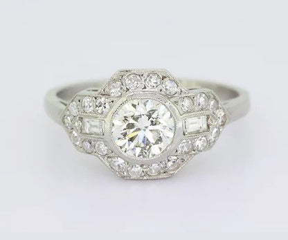 Art Deco Style Diamond Cluster Ring; 0.80ct brilliant-cut diamond with geometric diamond surround, baguette cut diamonds on the shoulders, 18ct white gold.