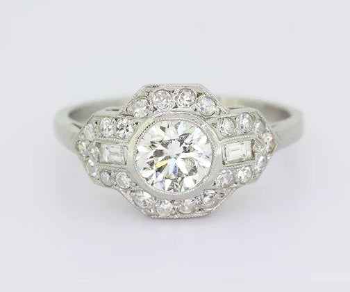 Art Deco Style Diamond Cluster Ring; 0.80ct brilliant-cut diamond with geometric diamond surround, baguette cut diamonds on the shoulders, 18ct white gold.
