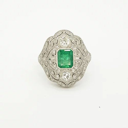 Colombian Emerald, Diamond and Platinum Openwork Plaque Ring; studded with diamonds surrounding an emerald-cut emerald