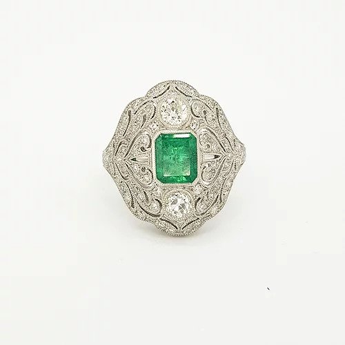 Colombian Emerald, Diamond and Platinum Openwork Plaque Ring; studded with diamonds surrounding an emerald-cut emerald