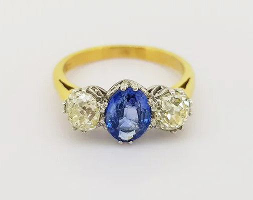 1.20ct Sapphire and 1.35ct Diamond Three Stone Ring; classic trilogy ring, central oval sapphire flanked by two round-cut diamonds. Mounted in 18ct white gold settings on an 18ct yellow gold shank.