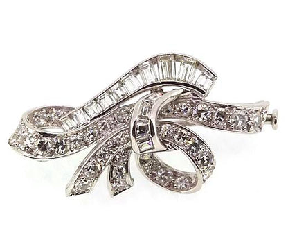 Vintage Diamond Bow Brooch; classic vintage bow brooch set with brilliant-cut and baguette-cut diamonds. Crafted from 18ct white gold