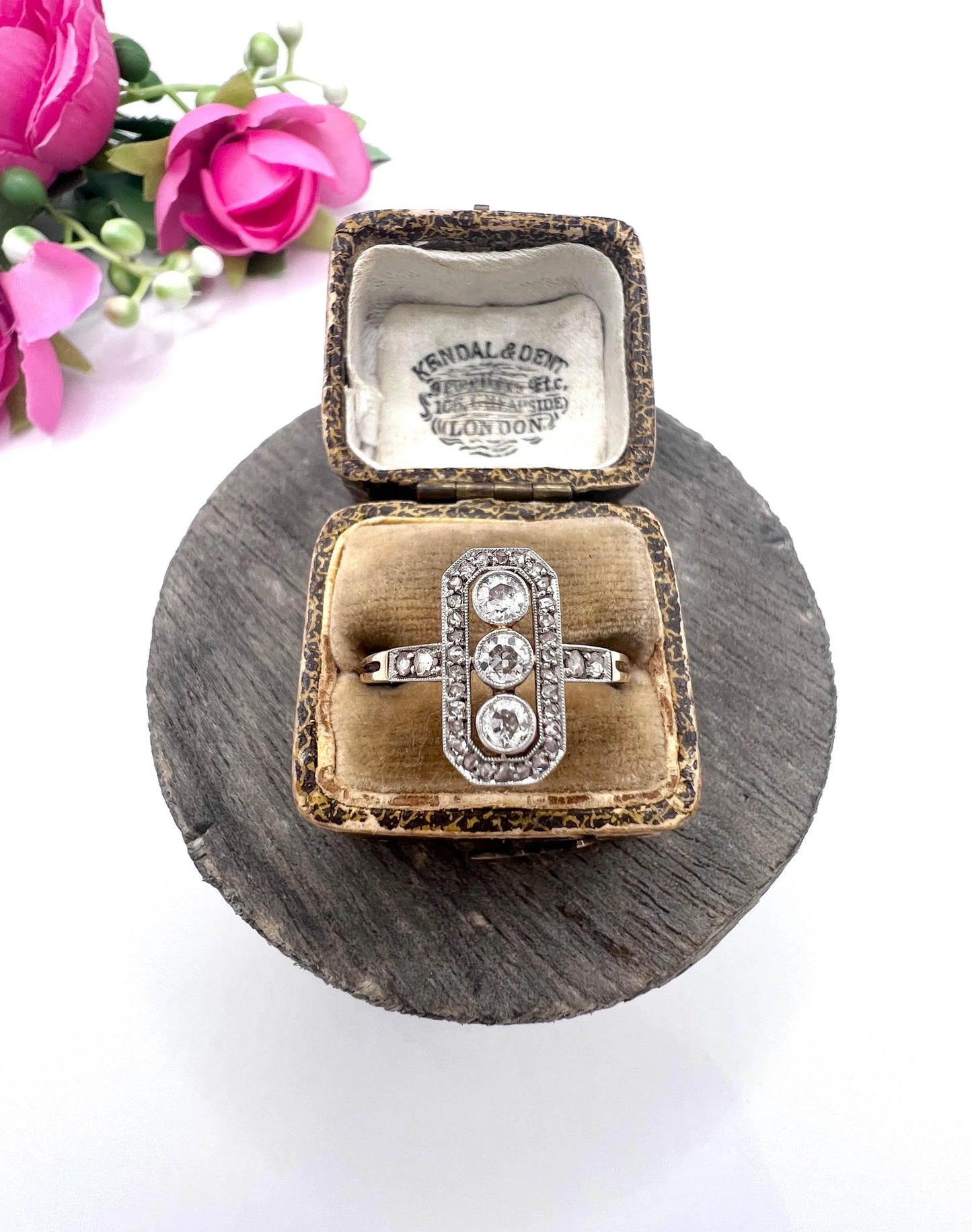 A diamond open cluster ring with three principal diamonds, in yellow and white gold, in a ring box